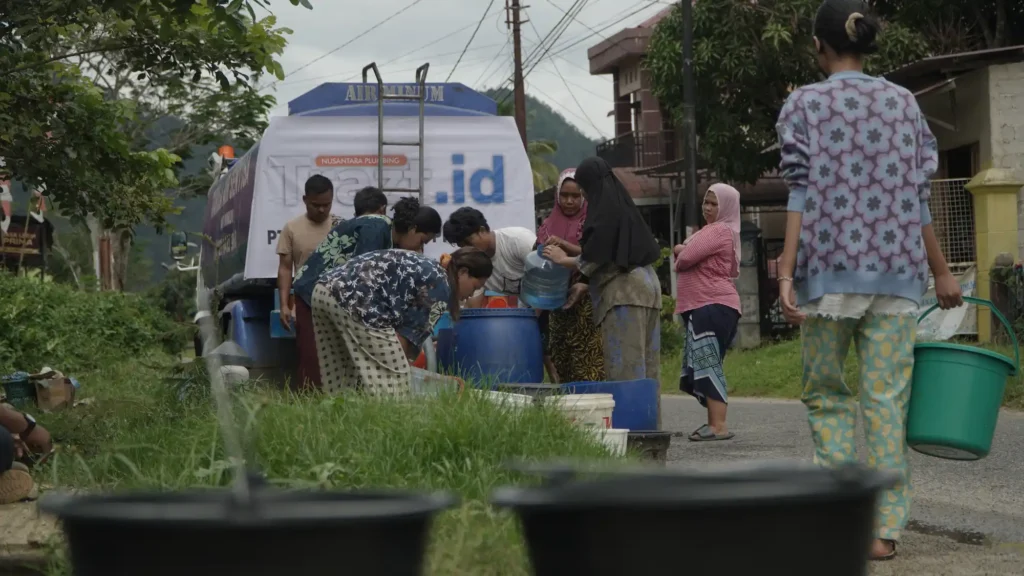 Foto warga terlihat tertib mengantre dan mengambil air menggunakan ember, jeriken, serta berbagai wadah lainnya untuk kebutuhan sehari-hari. 16 Desember 2025 